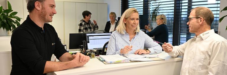 Bild zeigt drei Menschen am Empfang der AURON GmbH