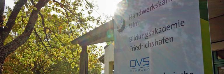Bild zeigt den sonnigen Eingang der Bildungsakdemie der Handwerkskammer Ulm